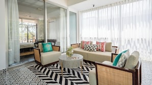 Una sala de estar moderna con sofá, sillones, una mesita de centro y una alfombra estampada.