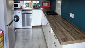 Une cuisine compacte équipée d’un four à micro-ondes, d’un lave-vaisselle et d’une cuisinière.