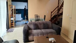 Un salon avec un canapé, une table basse et un escalier.