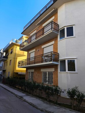 Ein mehrstöckiges Wohngebäude mit Balkonen, einer Ziegel-Fassade und einem verschlossenen Eingang.
