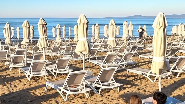 A beach with rows of sun loungers and umbrellas, a clear sky, and the sea in the background. - Cemsa Sunparadise BOUTİQUE HOTEL (Alanya)