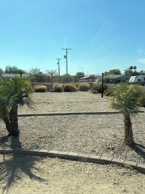 A parking lot with gravel ground, palm trees, and utility poles. - Dual Estate | 19BR | 2 Pools + Hot Tub | 32 (Phoenix)