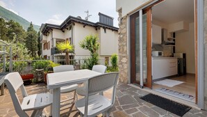 Eine Terrasse im Freien mit Tisch und Stühlen, einem Steinboden und Bergblick.