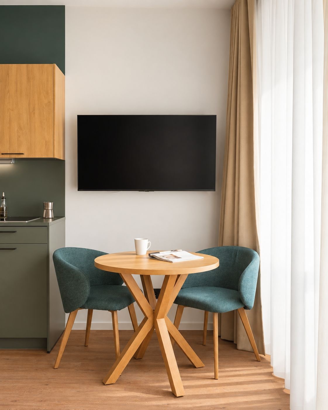 Une cuisine moderne équipée d’un téléviseur à écran plat, de deux chaises de couleur turquoise et d’une table à manger en bois.