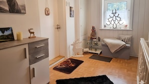 A modern kitchen with a wooden countertop, a white cabinet, and a black rug. - Apartment 'Hirschkönig' with Mountain View (Bad Lauterberg im Harz)