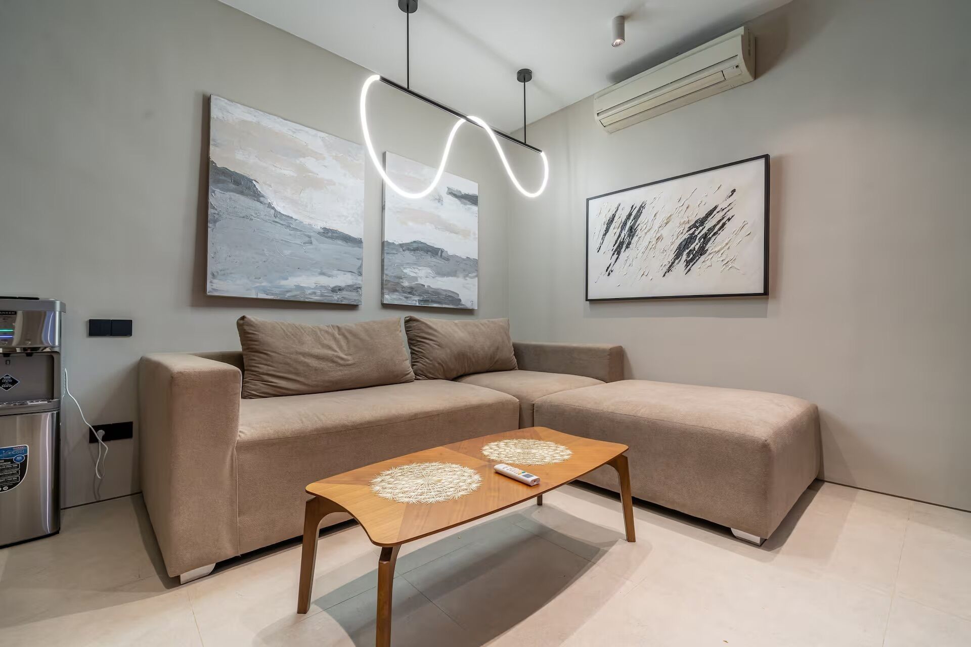 Una sala de estar moderna con un sofá, una mesa de centro y arte abstracto en las paredes.