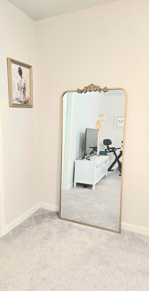 A room with a large mirror, a white dresser, and a framed picture on the wall. - Luxury Beach and Golf Villa W/ Fenced yard (Sunset Beach)