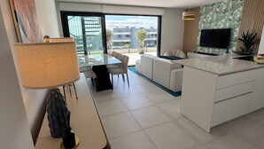 A modern apartment with a dining area, kitchen, and living space, featuring large windows and a view of the city. - Luxury Penthouse with the view (Estepona)
