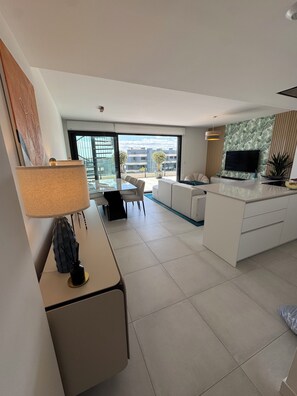 Um apartamento moderno com cozinha, sala de jantar e varanda com vista para a cidade.