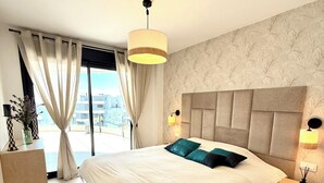 A modern bedroom with a large bed, a view of the city, and a minimalist decor. - Luxury Penthouse with the view (Estepona)