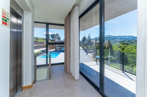 A balcony with a pool view, large windows, and a fire safety sign.