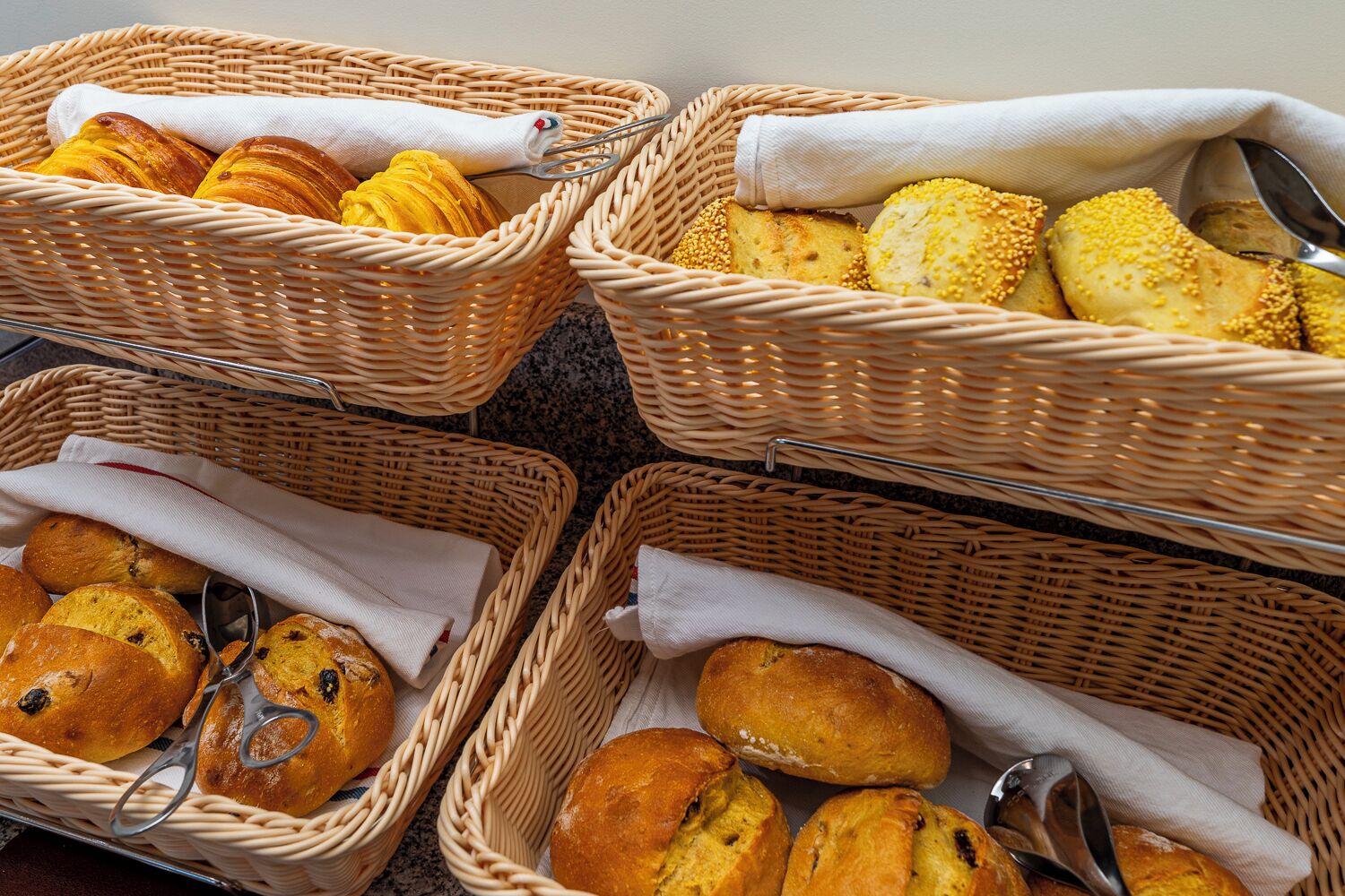Four wicker baskets containing various baked goods.
