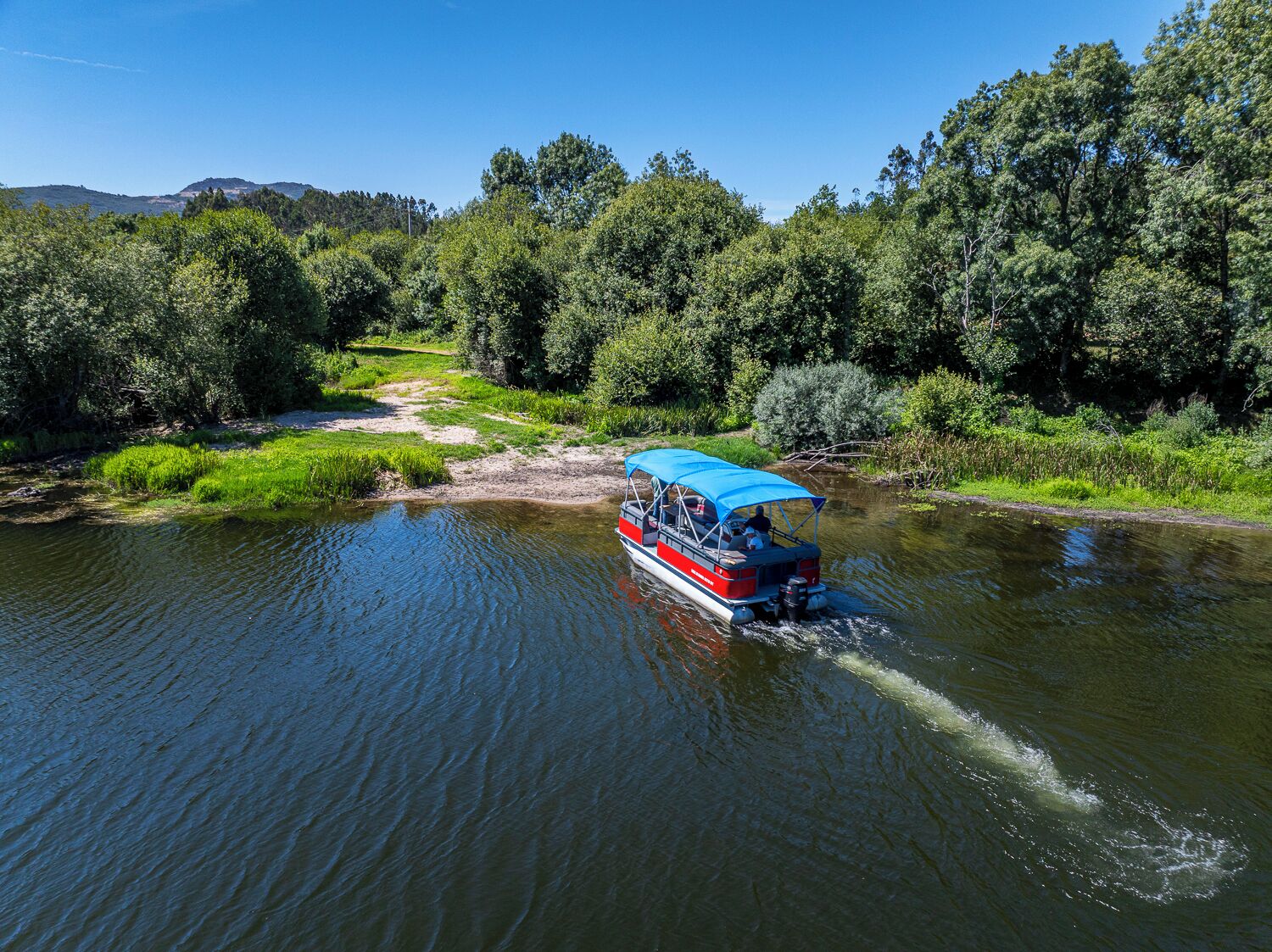 A boat on a river surrounded by dense greenery.
