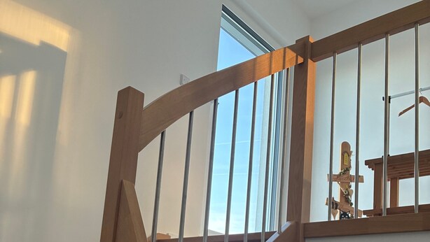 A wooden staircase with metal railings, leading to an upper floor with a large window. - Apartment 'Hedwig Und Anna' with Balcony and Wi-Fi (Zapfendorf)