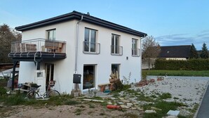 A two-story house with a balcony, a bicycle, and a gravel driveway. - Apartment 'Hedwig Und Anna' with Balcony and Wi-Fi (Zapfendorf)