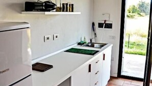 A compact kitchen with a white countertop, a built-in sink, and a refrigerator. - Studio apartments near Baratti Bay (Toscana)