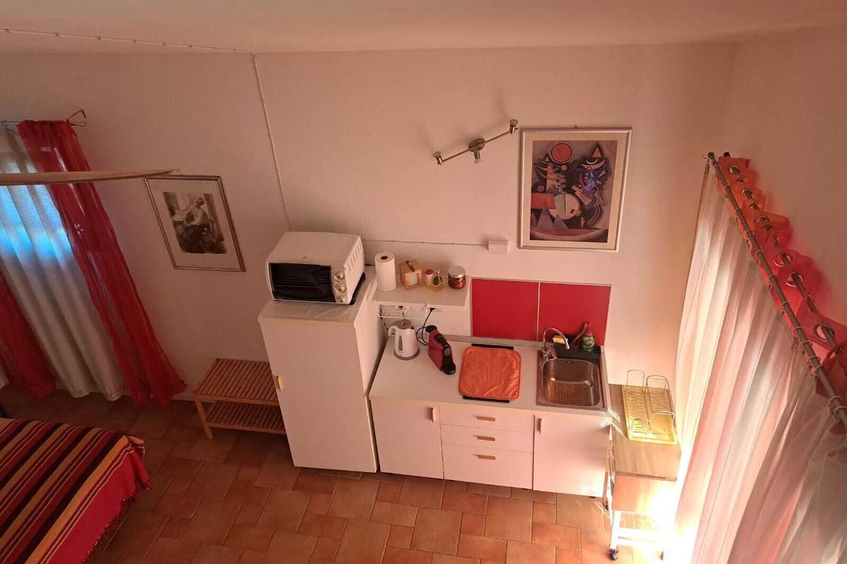 Une cuisine compacte équipée d’un four à micro-ondes, d’un évier et d’un petit plan de travail.