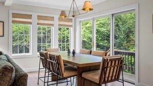 A dining area with a large wooden table, six chairs, and a chandelier. - Topnotch Luxury Retreat | Sleeps 12 • Pet Friendly • Game Room (Stowe)