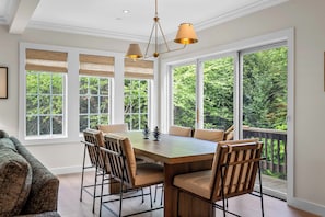 A dining area with a large wooden table, six chairs, and a chandelier. - Topnotch Luxury Retreat | Sleeps 12 • Pet Friendly • Game Room (Stowe)