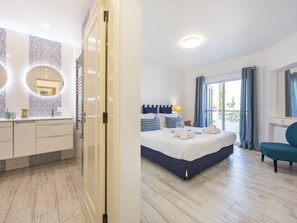 Ein Schlafzimmer mit Bett, Nachttisch und Blick ins Freie.