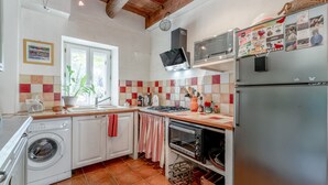 Una cocina funcional con lavadora, horno y microondas.