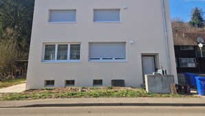 A multi-story building with a flat roof, large windows, and a visible garage door. - Cozy guest rooms in a modern, renovated apartment (Schwäbisch Gmünd)
