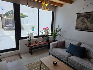 Una sala de estar moderna con un sofá, una mesa de centro y un ventanal con vistas al exterior.