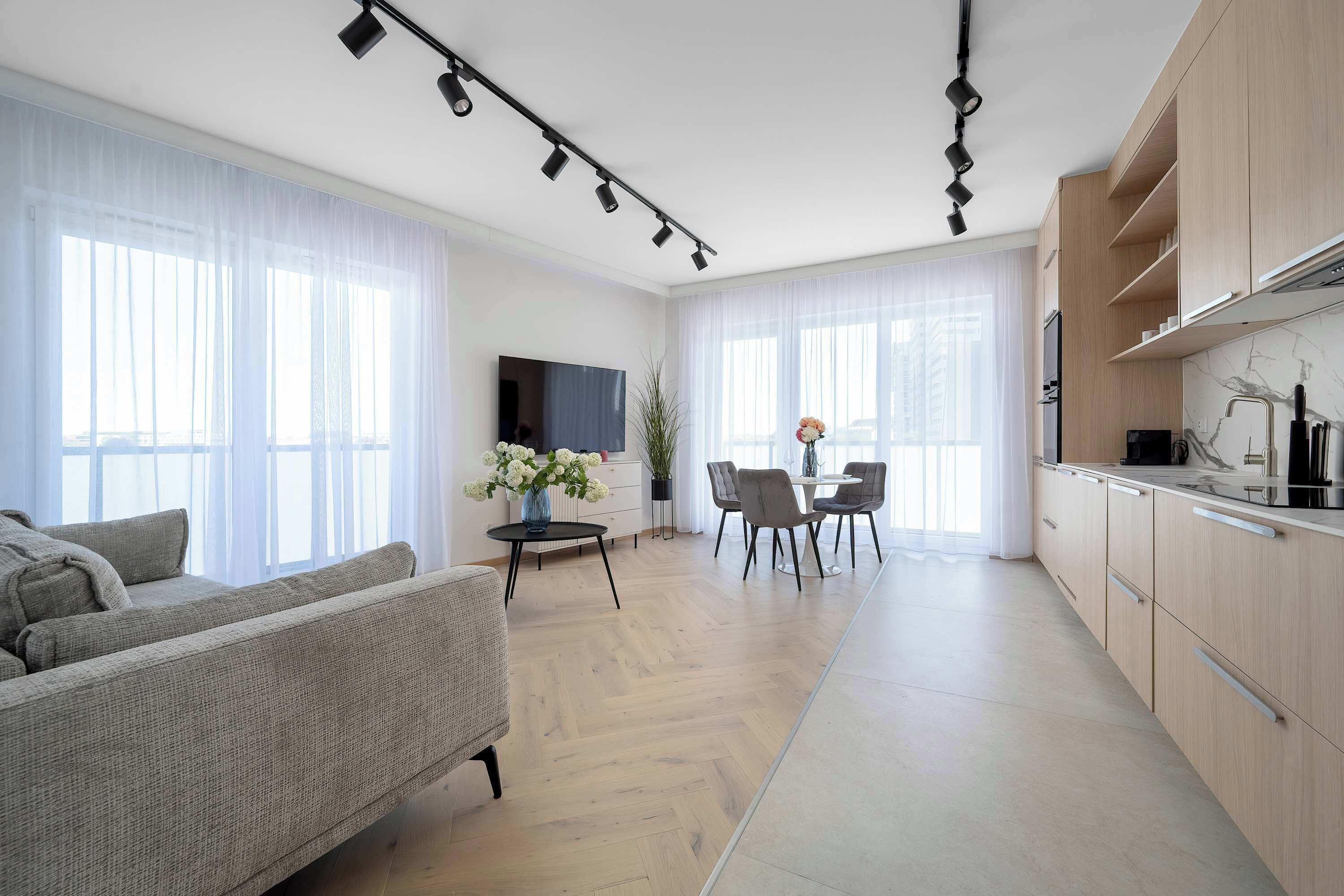 Una sala de estar moderna con sofá, comedor y cocina.