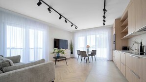 Una sala de estar moderna con sofá, comedor y cocina.