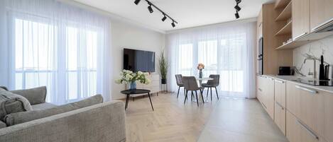 Una sala de estar moderna con sofá, comedor y cocina.