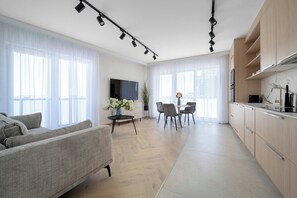 Ein modernes Wohnzimmer mit Sofa, Essbereich und Küche.