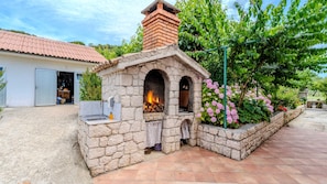 A stone-built outdoor kitchen with a chimney, a sink, and a fire pit. - Apartman Sunset View Rab by Villas Guide (Rab)