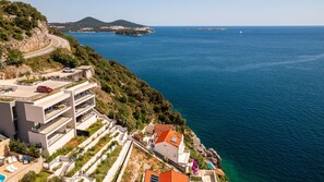 Ein Hotel an der Küste mit mehreren Etagen, einem Schwimmbad und Meerblick.