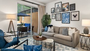 Una sala de estar moderna con un sofá, una mesa de centro y un comedor con sillas y una mesa.