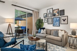 Een moderne woonkamer met een bank, salontafel en een eethoek met stoelen en een tafel.