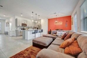 A modern kitchen with white cabinets, a central island, and pendant lighting. - 20 Mins to Disney Arcade Battles Mini Golf (Davenport)