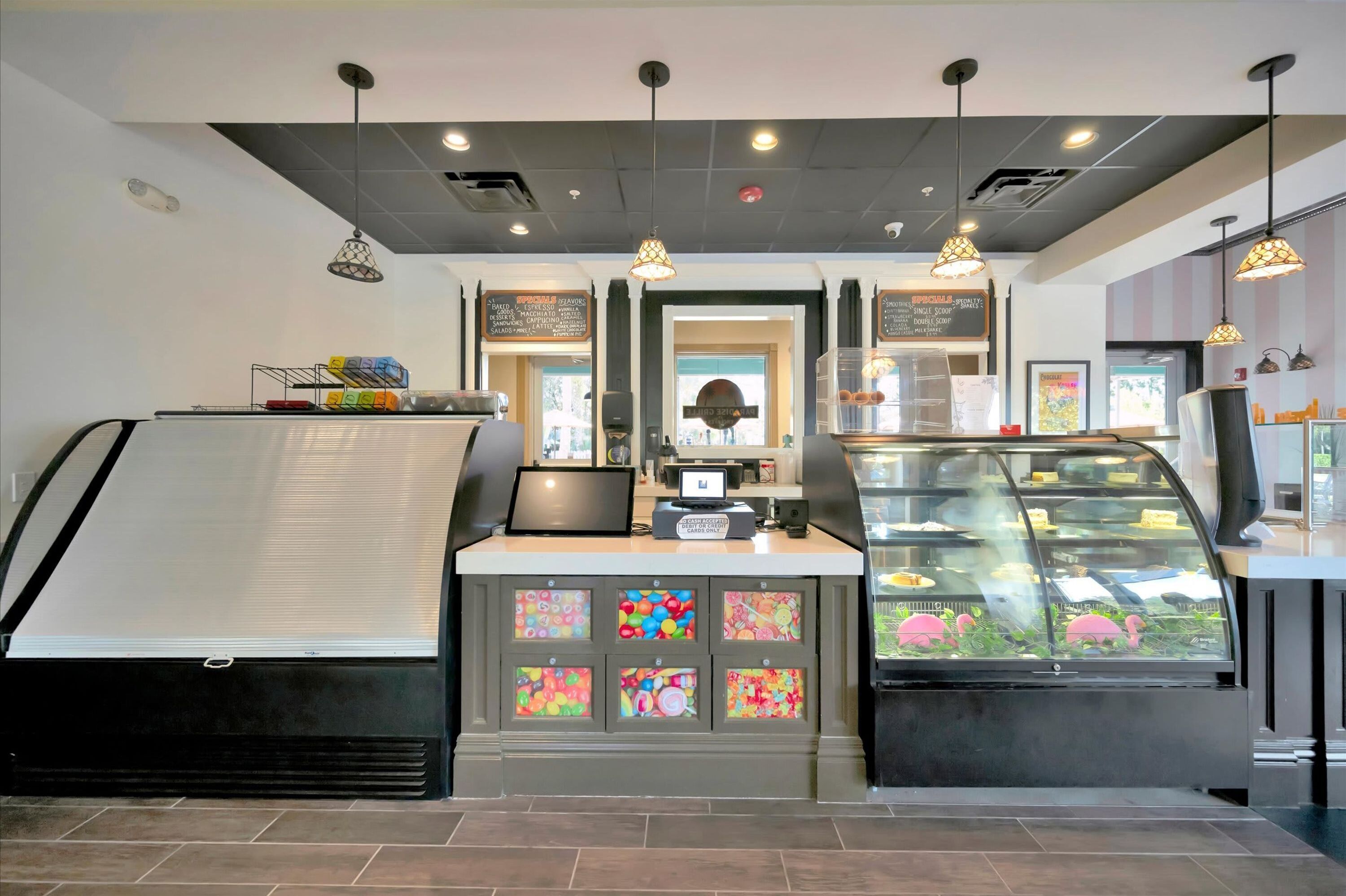 A bakery interior with a display case, a counter, and a cash register.
