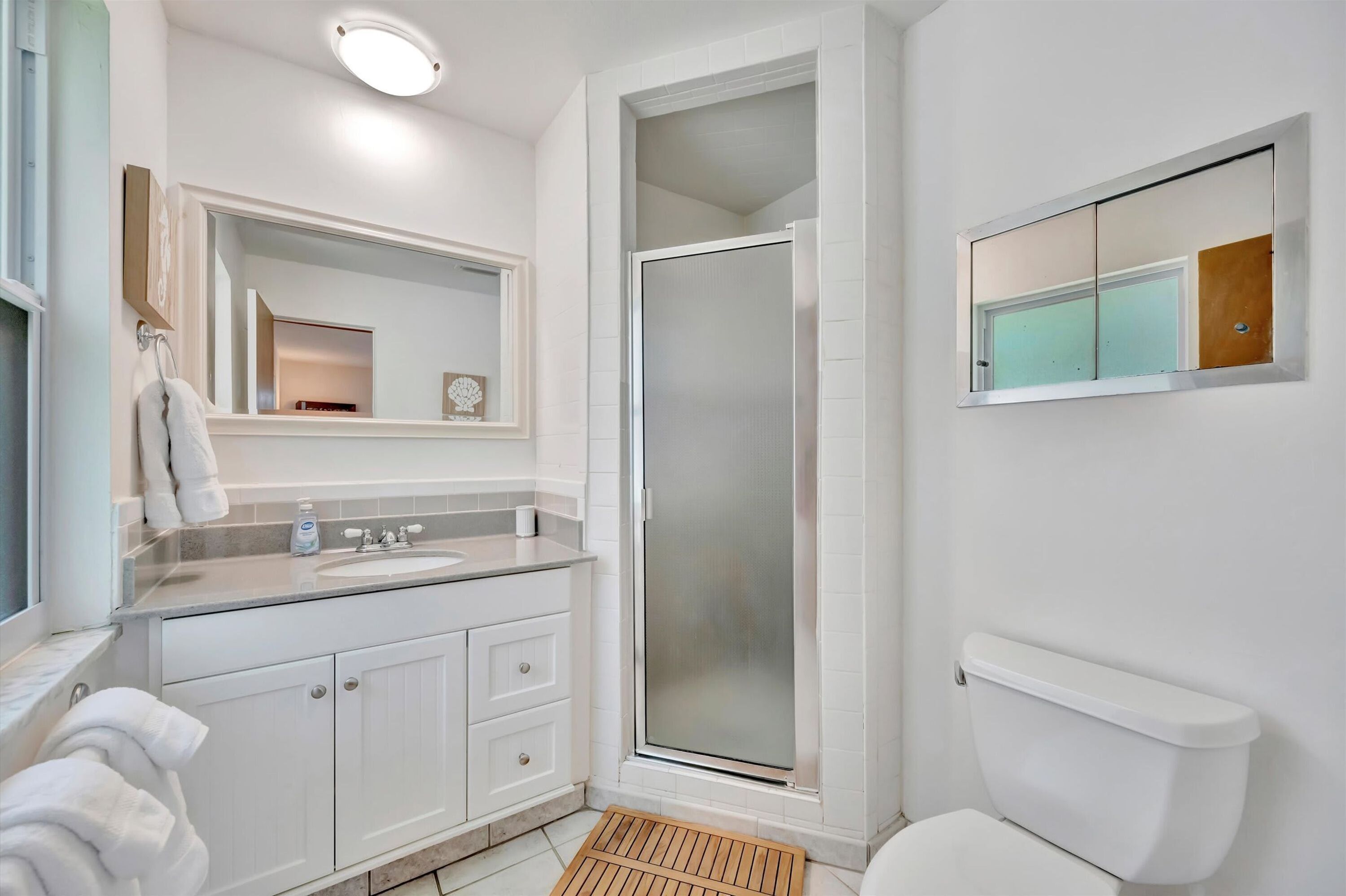 A bathroom with a shower, toilet, and sink.