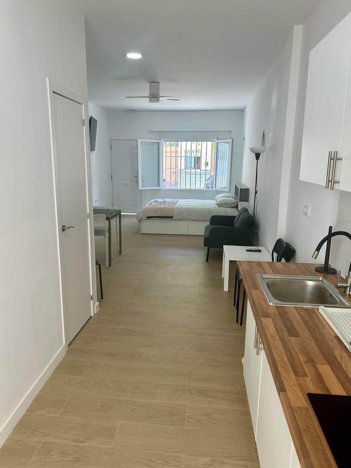 Una cocina moderna con encimera de madera, pileta integrada y ventilador de techo.