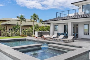 Ein moderner Poolbereich mit Liegestühlen, einem Grill und einer Terrasse mit Sitzgelegenheiten.