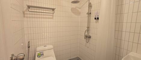 Ein kleines Badezimmer mit Toilette, Dusche und Waschbecken.
