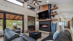 A modern living room with a fireplace, leather sofas, and a television. - New in Powder House! Pet Friendly, 4 Ensuites, Iconic Wraparound Deck (Lead)