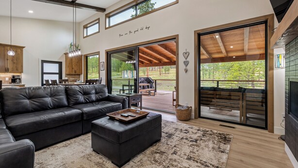 A modern living room with a sectional sofa, a coffee table, and a large window. - New in Powder House! Pet Friendly, 4 Ensuites, Iconic Wraparound Deck (Lead)