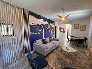 Un salon moderne avec un canapé, une table à manger et des chaises.