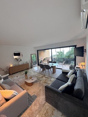 A modern living room with a sofa, coffee table, and dining area. - Apartment Cannes Eden luxury residence (Vallauris)