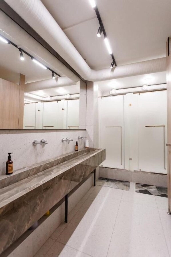 A modern bathroom with a marble vanity, a large mirror, and a separate shower area. - Luxx Aparts (Almaty)