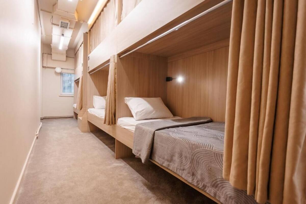 A room with bunk beds, a window, and a ceiling light.