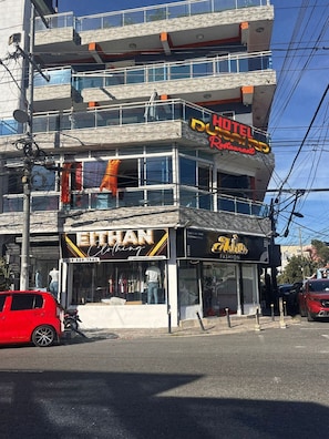 Un edificio de varios pisos con un restaurante llamado 'HOTEL Restaurant' en la planta superior.
