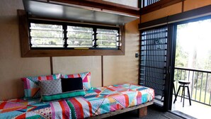 A single bed with a colorful quilt, a window with blinds, and a balcony with a railing. - Gorgeous Queensland Tree House with Great Views Perfect for Glamping, Gold Coast (Gold Coast)