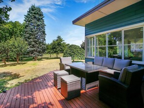Un patio exterior con una mesa de comedor y sillas, un sofá y una mesita.